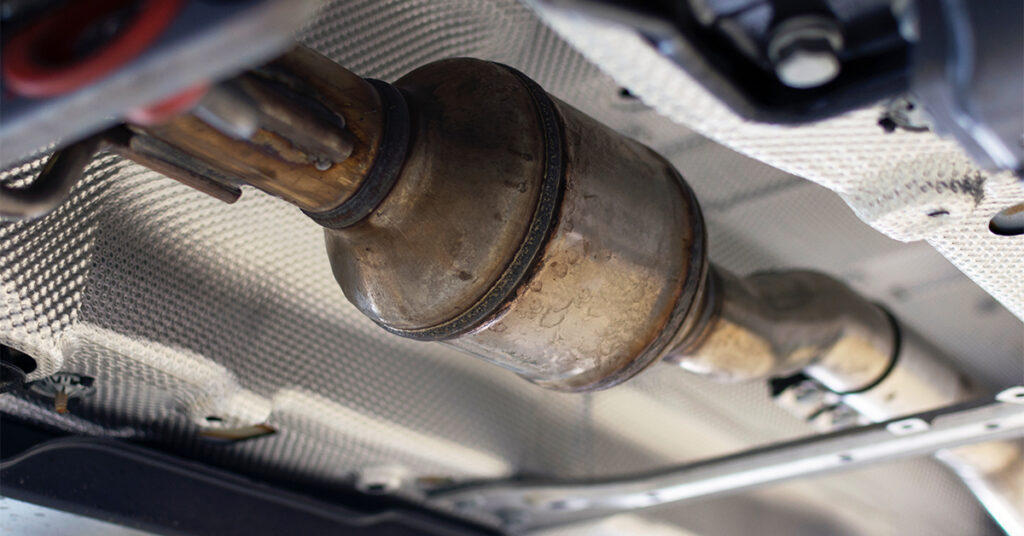 A catalytic converter underneath a vehicle.