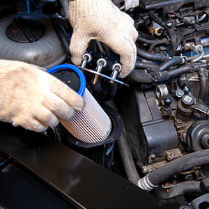 Closeup of a Pearson Auto technician's hands carefully checking the fuel system.