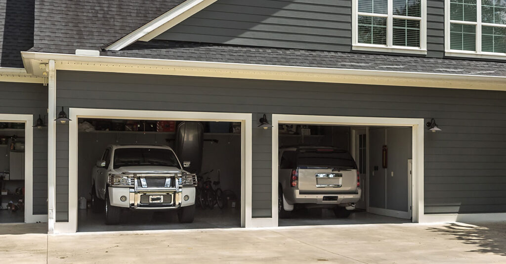 Two seldom-driven cars are parked inside a garage.