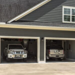 Two seldom-driven cars are parked inside a garage.